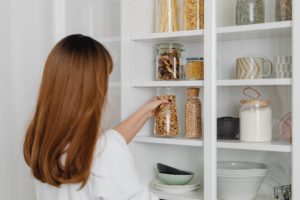 a woman in white shirt holding clear glass jar