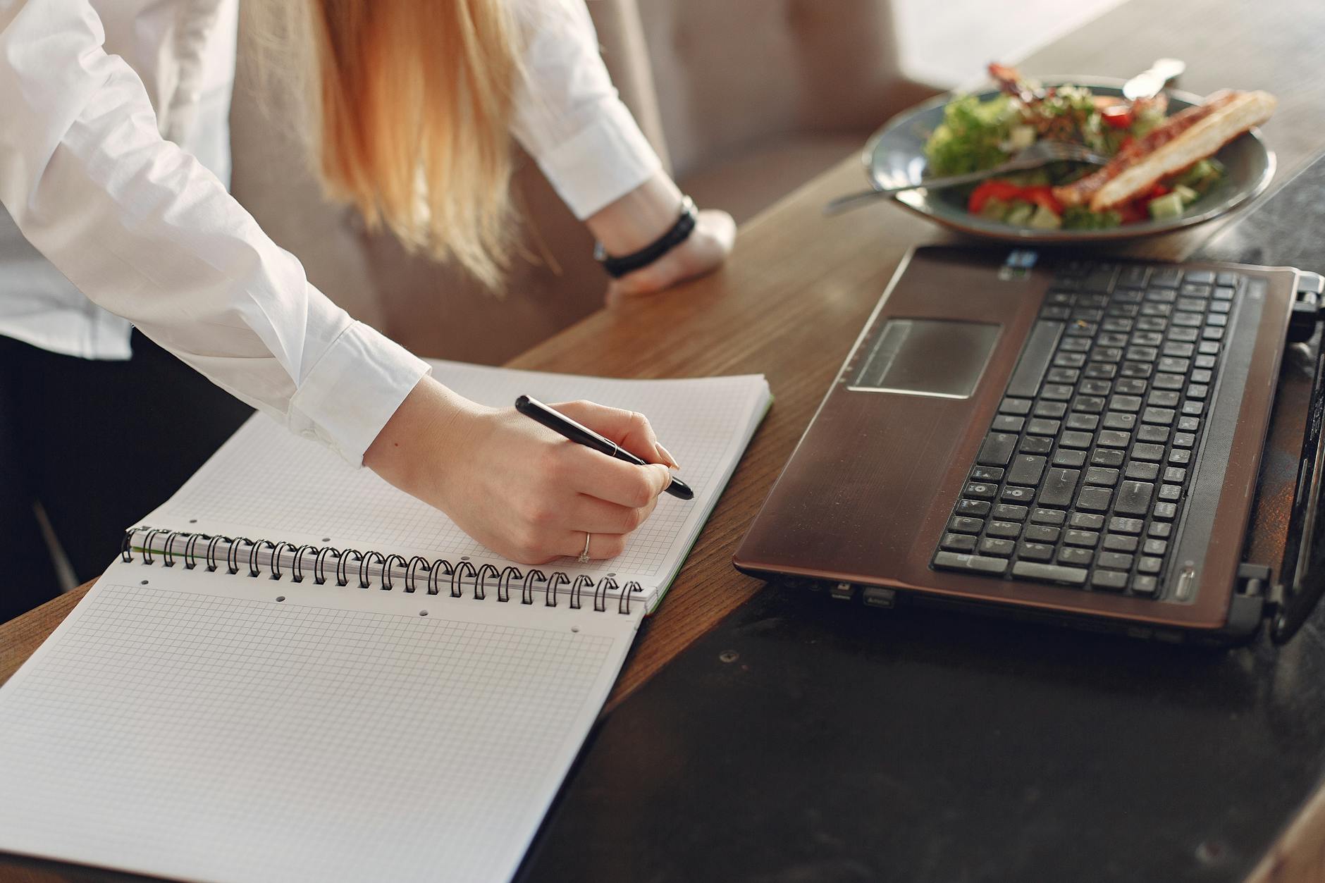 young businesswoman working remotely in cafe during lunch time